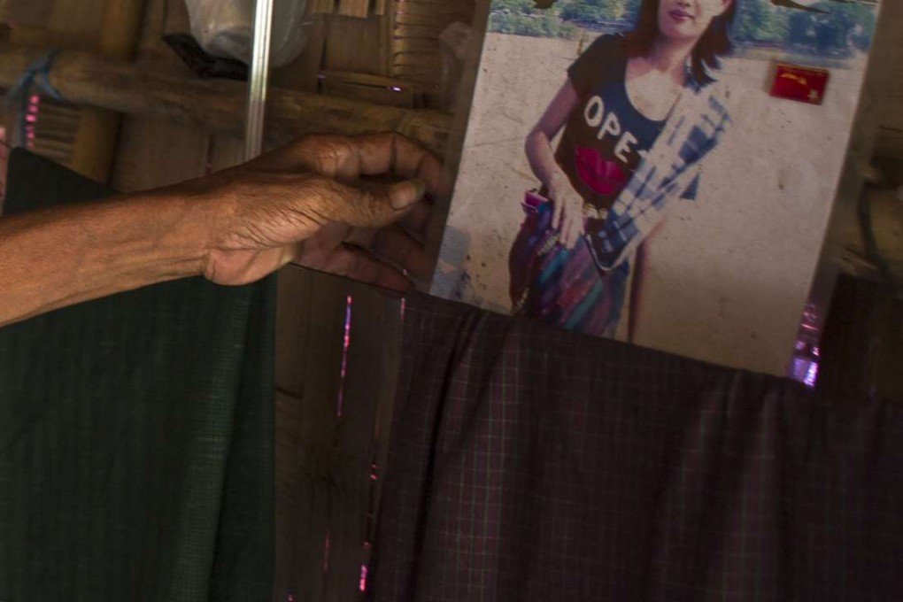 Mya Soe holds a photograph of his daughter Kyi Pyar Soe, who fell into a marriage trap after being lured by work in China. Photo: AFP