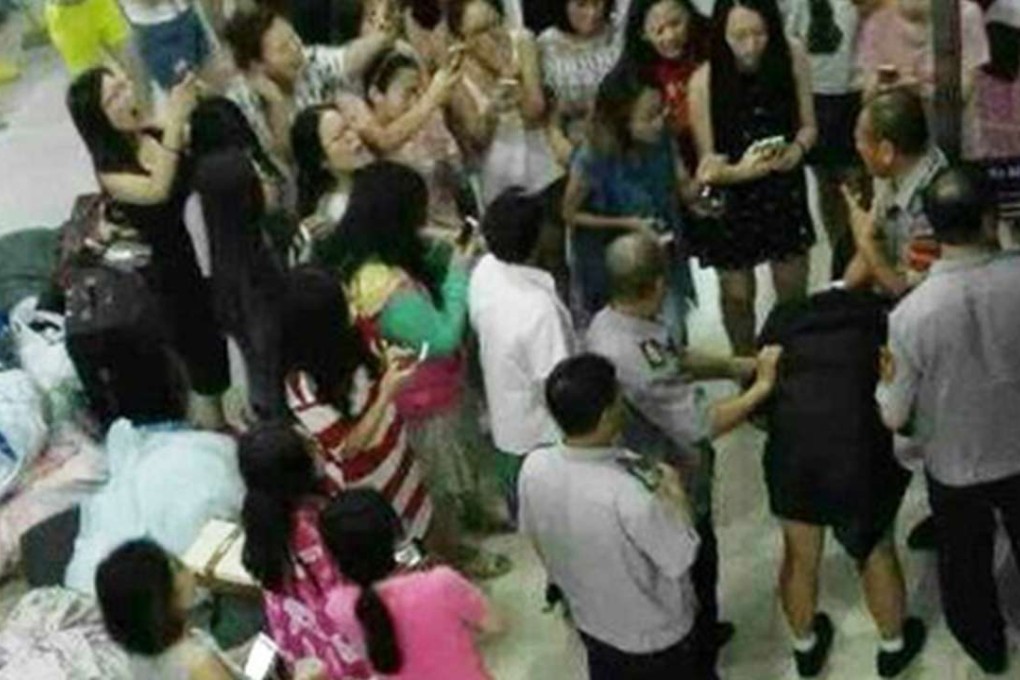 Female students and security guards surround the male student after he is caught in the women’s dormitory on the campus of Shenyang Aerospace University in Shenyang, Liaoning province. Photo: Sina.com