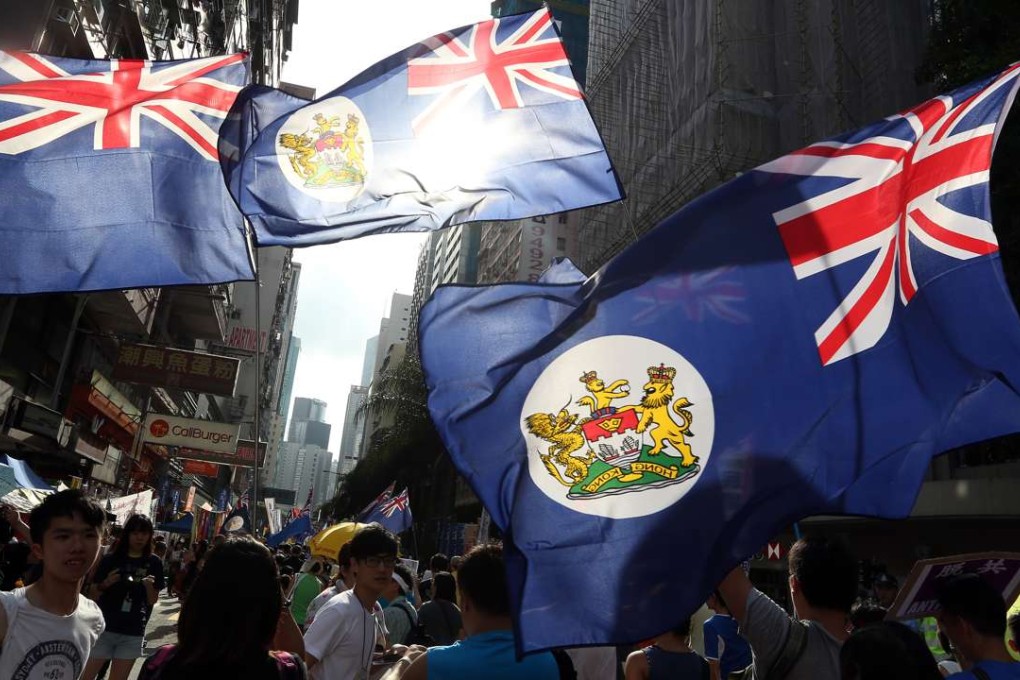 Colonial flags are waved during the July 1 march in Wan Chai in 2015. Photo: Felix Wong