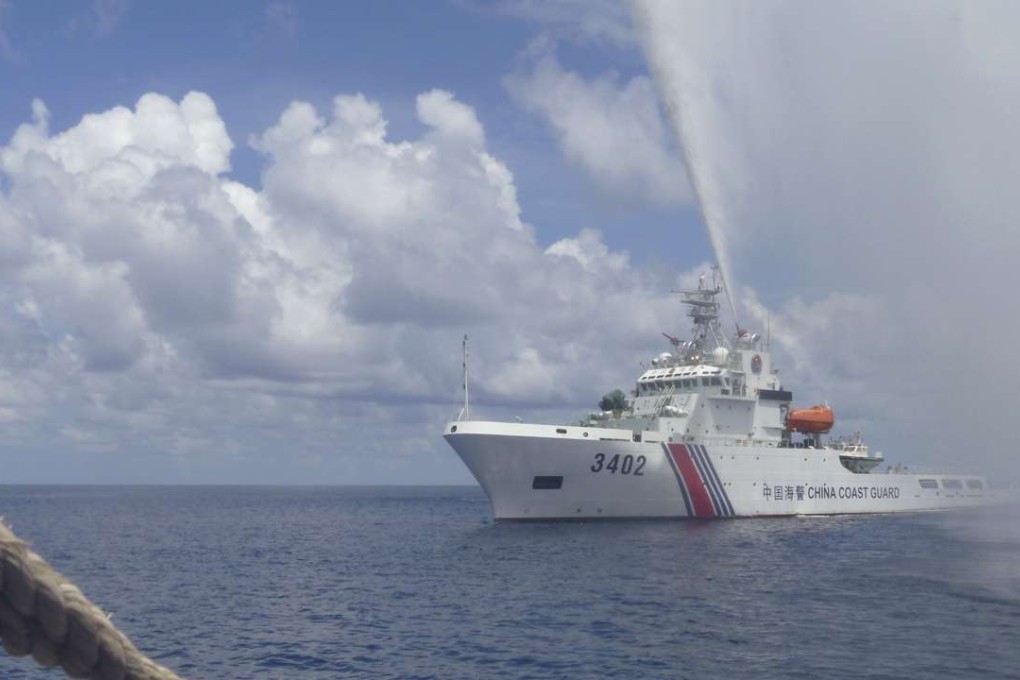 A Chinese coast guard boat sprays a water cannon at Filipino fishermen near Scarborough Shoal in the South China Sea. The Permanent Court of Arbitration in The Hague has set July 12 to deliver its decision on a key case involving the South China Sea. Photo: AP
