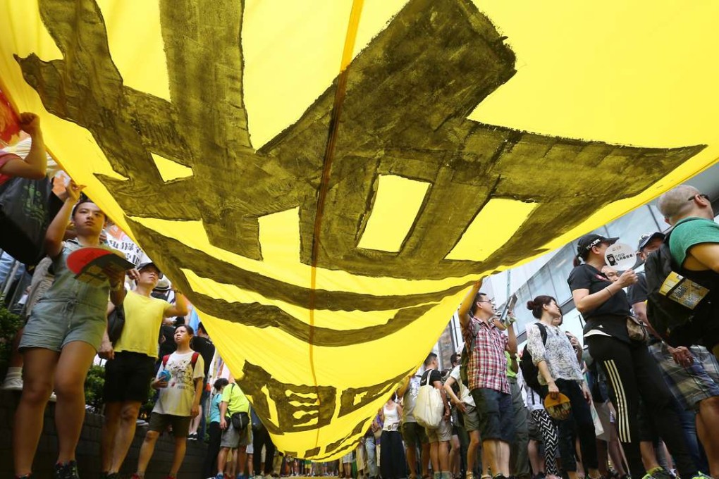 Marchers carry a huge banner at the head of the procession. Photo: K. Y. Cheng