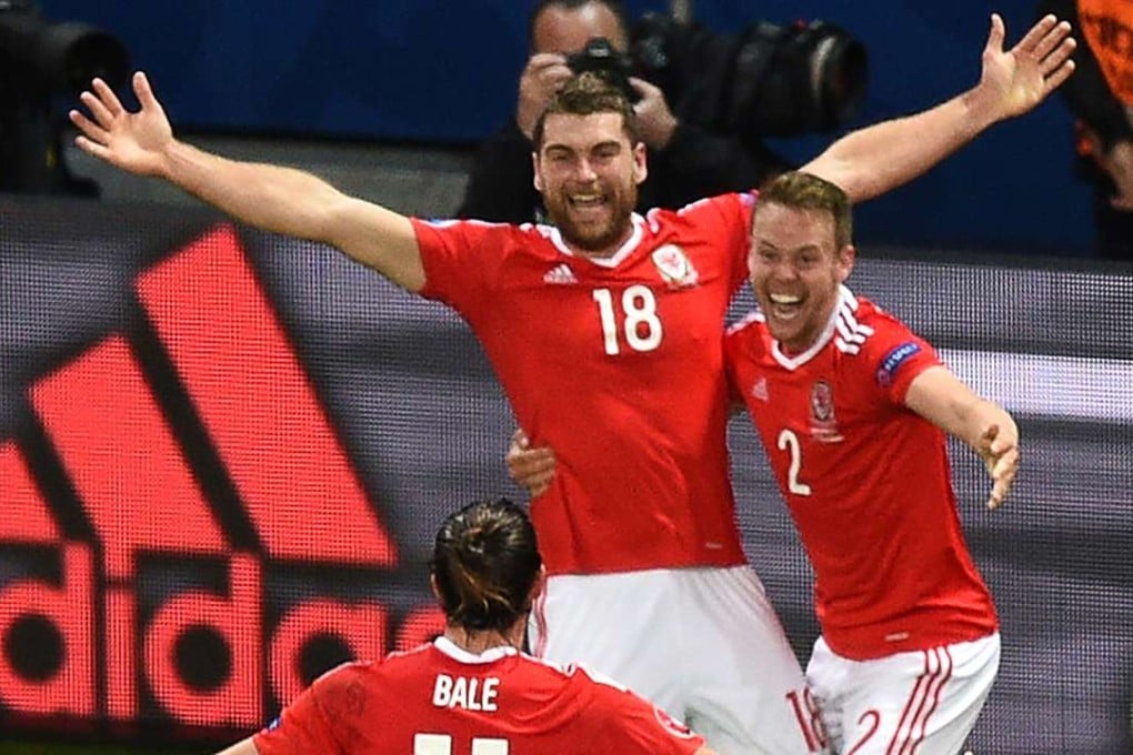 Wales' forward Sam Vokes (C) celebrates with teammates after scoring the killer third AFP PHOTO / DENIS CHARLET