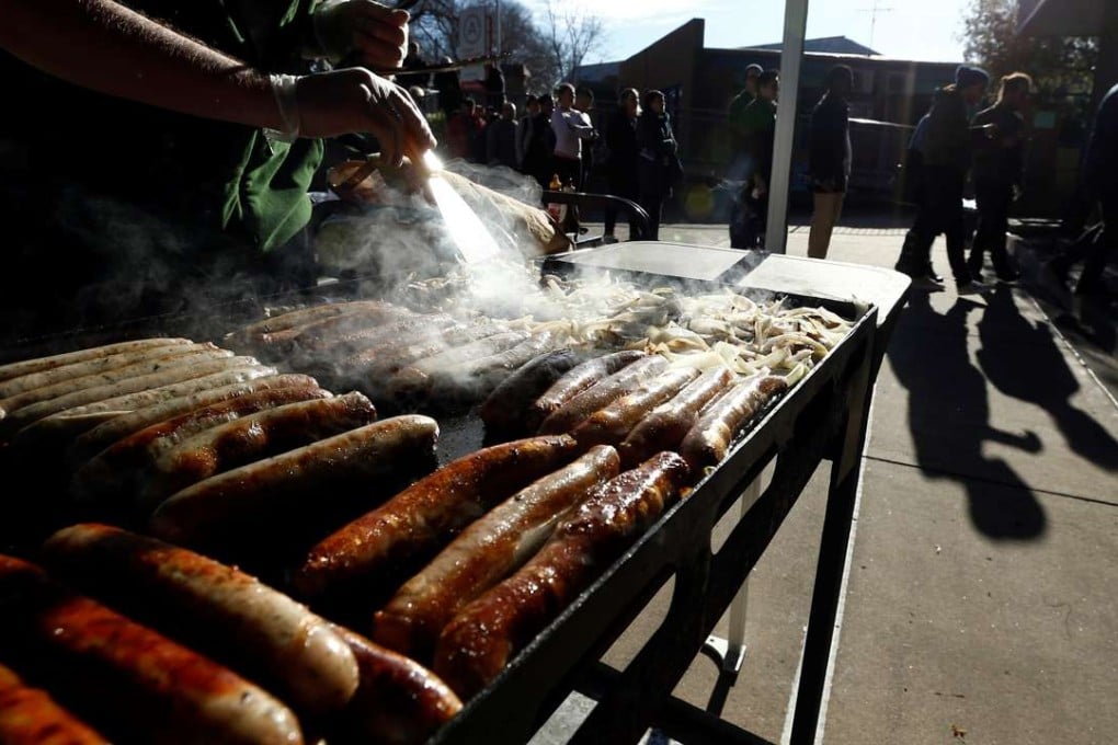 A traditional Australian 'sausage sizzle' barbeque offers sausage-and-onion sandwiches to hungry voters as they queue up at a polling station at Mount Alexander College in Flemington, Melbourne. Photo: Reuters