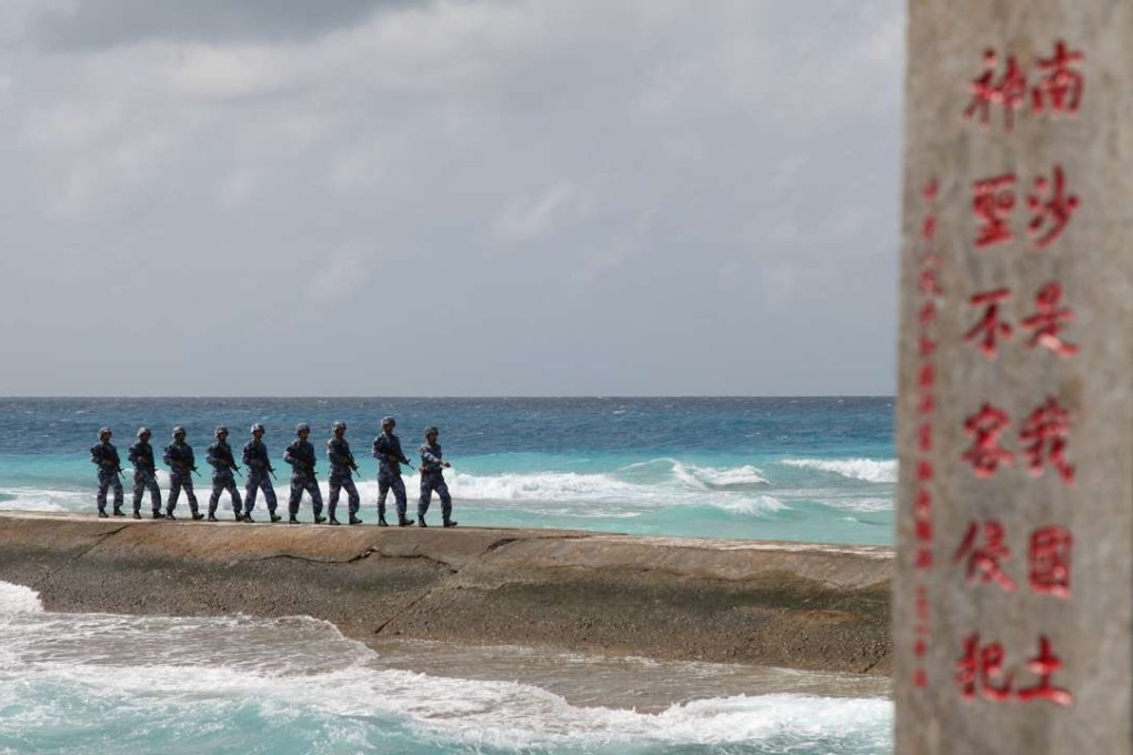 People's Liberation Army Navy soldiers patrol near a sign in the Spratly Islands reading ‘Nansha is our national land, sacred and inviolable’. Photo: Reuters