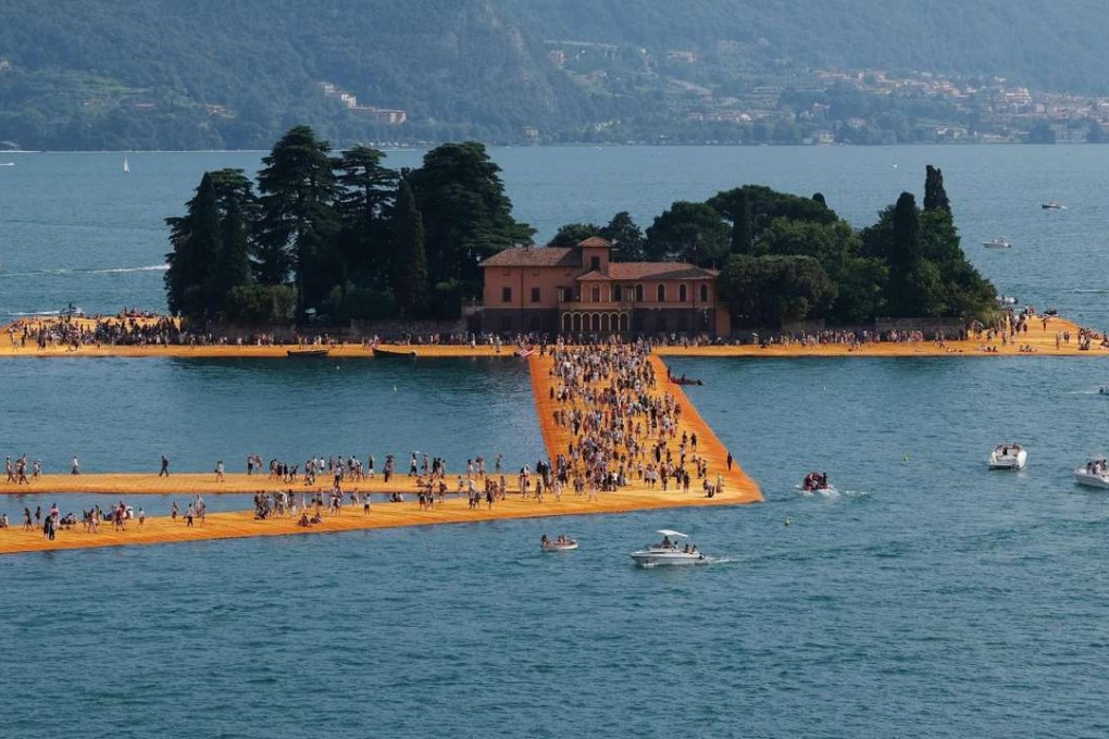 People walk on the The Floating Piers installation by artist Chisto on Lake Iseo, Italy, during the last day of the artwork on Sunday. Photo: EPA