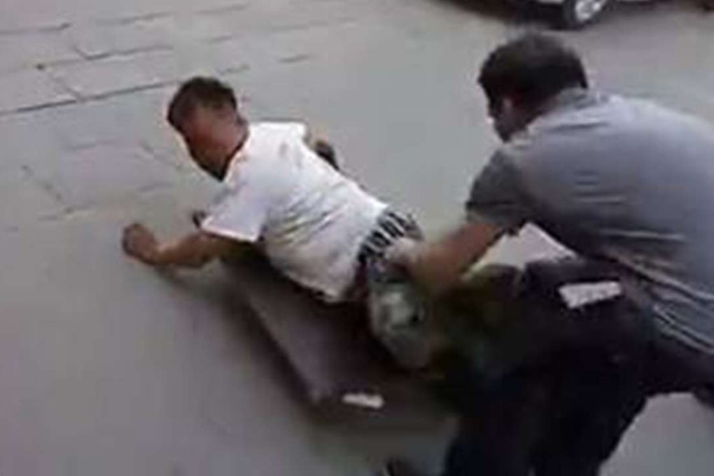 The passer-by pulls off the beggar’s trousers in Altay, Xinjiang. Photo: SCMP Pictures