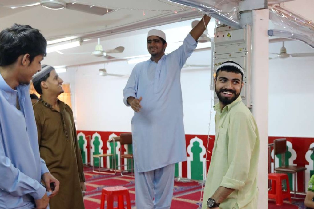 Muslims share a light moment as they decorate the Idara Minhaj-ul-Quran mosque in Kwai Chung in preparation for celebrations of the end of Ramadan. Photo: Bruce Yan