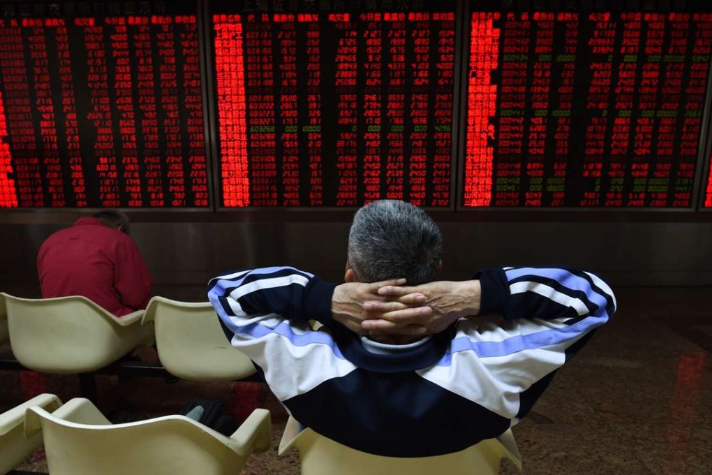An investor watches stock price movements at a securities company in Beijing. The Shanghai Composite Index at one point Tuesday touched 3,010.27 but lost momentum, closing at 3,006.39, up 0.6 per cent or 17.79 points. Photo: AFP