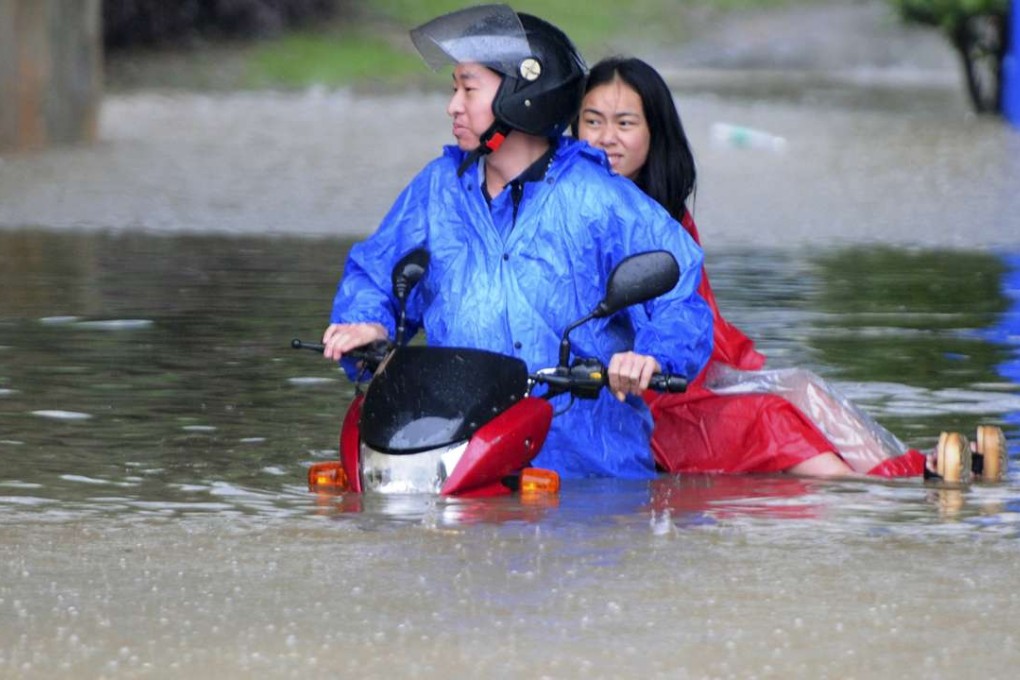 Residents try to get through flood waters on a scooter in Jiujiang, Jiangxi province. Photo: AP
