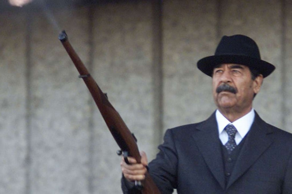 Former Iraqi president Saddam Hussein fires shots into the air during a military parade in Baghdad on December 31, 2000. Photo: Reuters