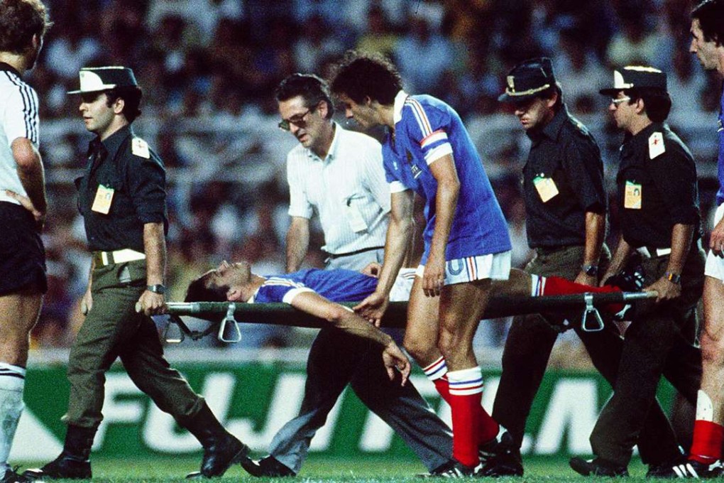Patrick Battiston evacuated on a stretcher eyed by forward Michel Platini after colliding with German goalkeeper Harald Schumacher during the World Cup semi-final. Photo: AFP
