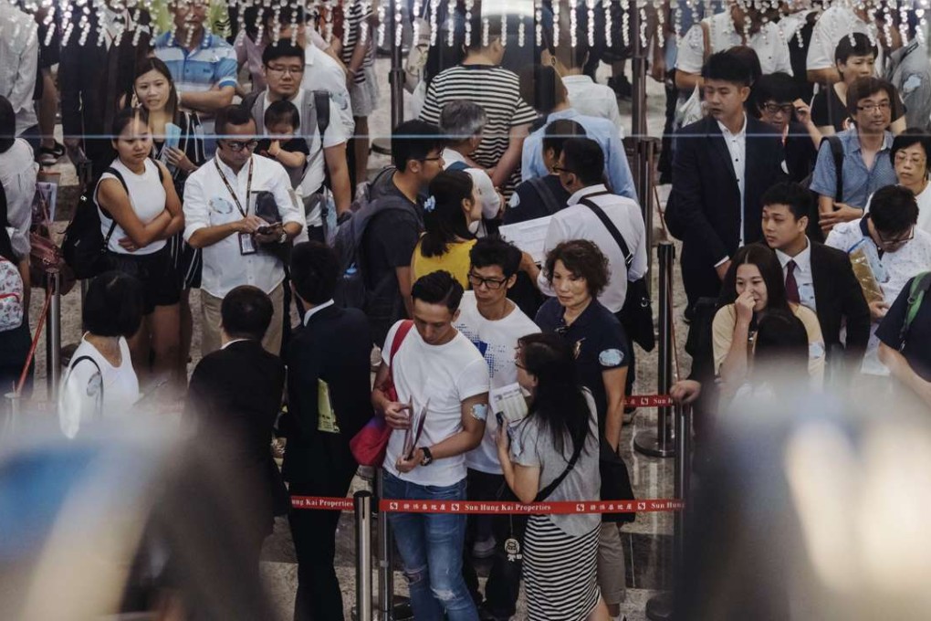 Potential buyers and real estate agents stand in line last month, outside the sales office of Park Yoho Venezia, a residential property developed by Sun Hung Kai Properties. Photo: Anthony Kwan, Bloomberg