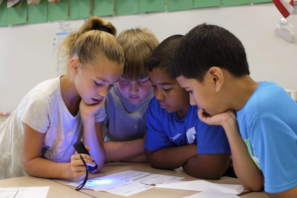 Children trying to figure out the way to get into a Breakout EDU box.