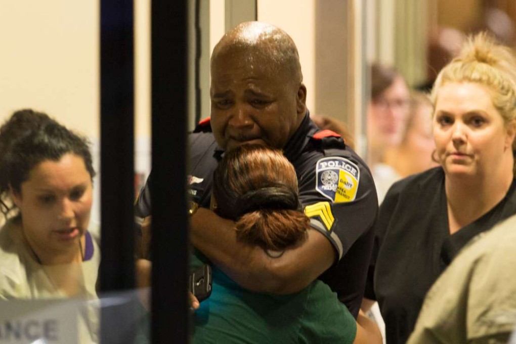 A DART (Dallas Area Rapid Transit) police officer receives comfort at Baylor University Hospital emergency room entrance on Thursday, July 7, 2016, in Dallas. Photo: TNS