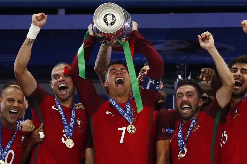 Portugal's Cristiano Ronaldo celebrates with team mates and the trophy after winning Euro 2016 REUTERS/Kai Pfaffenbach Livepic
