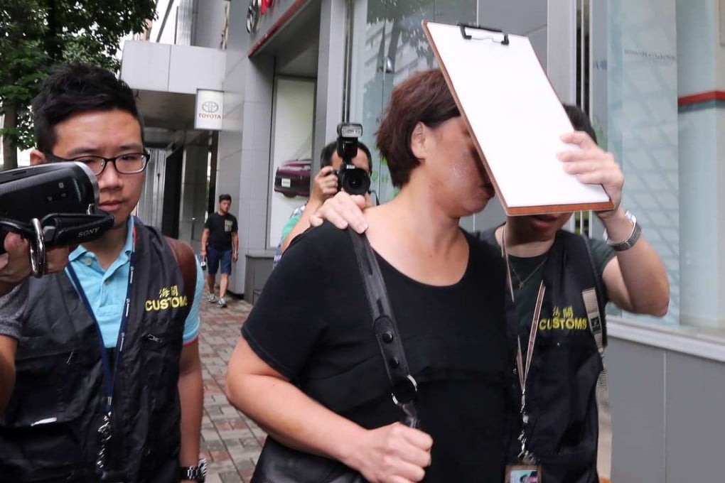An unidentified senior official of the California Fitness was taken away by officers of the Hong Kong Customs and Excise Department from the Kowloon Bay Office for further investigation.Photo: Felix Wong