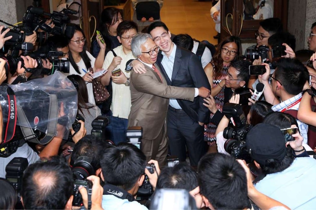 Thomas Kwok Ping-kwong (centre left) hugging his son Adam Kwok outside court in Central. Photo: Sam Tsang