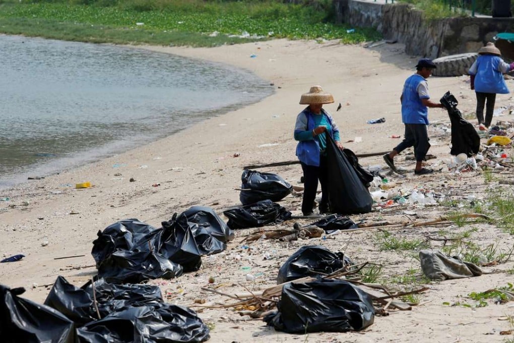 Workers cleaning up Nim Shue Wan beach on Lantau Island. Photo: Reuters