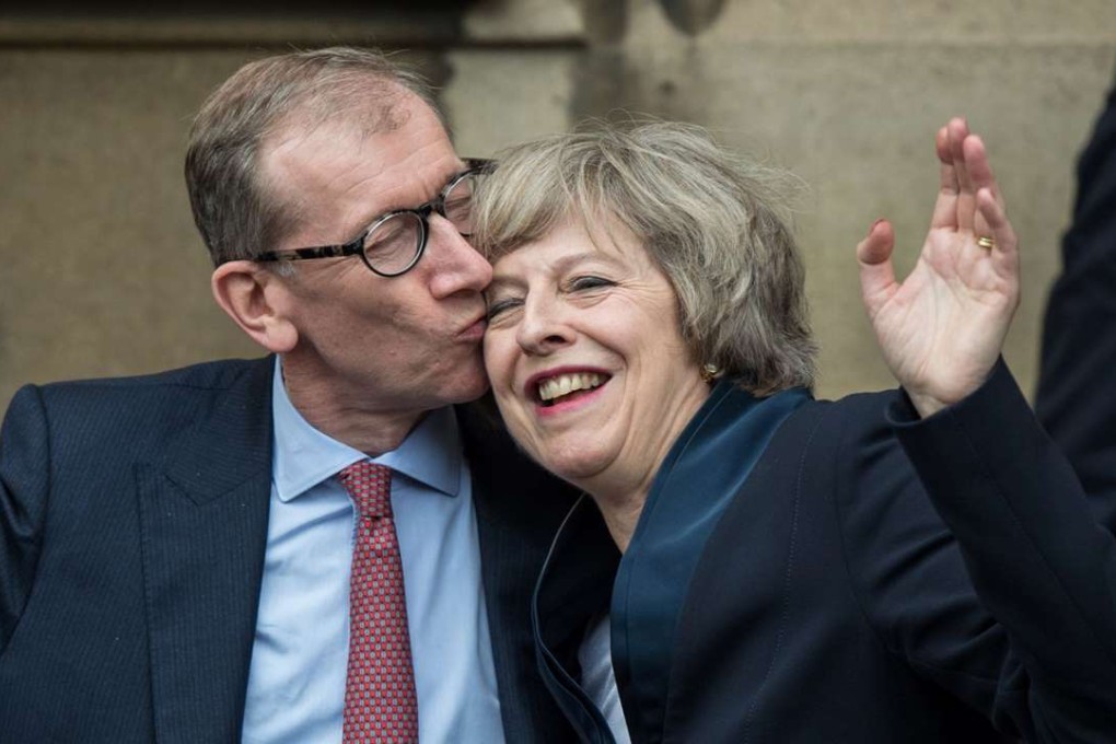 Britain's new Conservative Party leader and PM-in-waiting Theresa May receives a kiss from her husband Philip John May after speaking to the media at the Palace of Westminster in London on Tuesday. Photo: AFP
