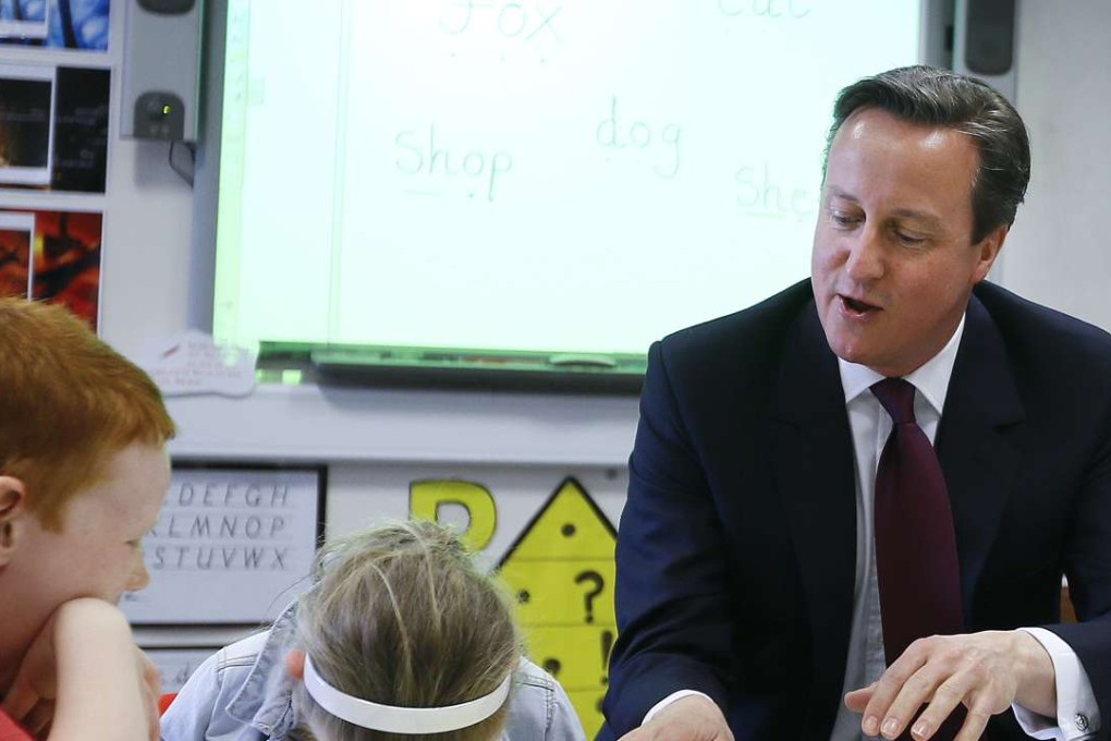 Britain's Prime Minister David Cameron reads a book to two children. Photo: AP