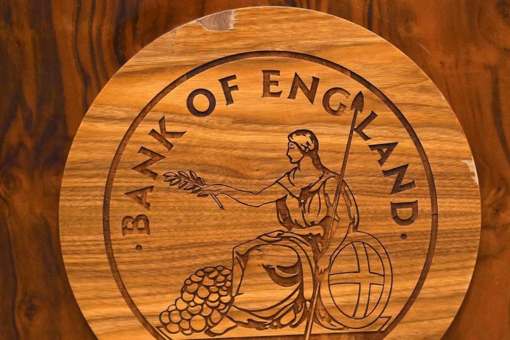 A wooden carving of the Bank of England logo is seen on a desk. Photo: Reuters
