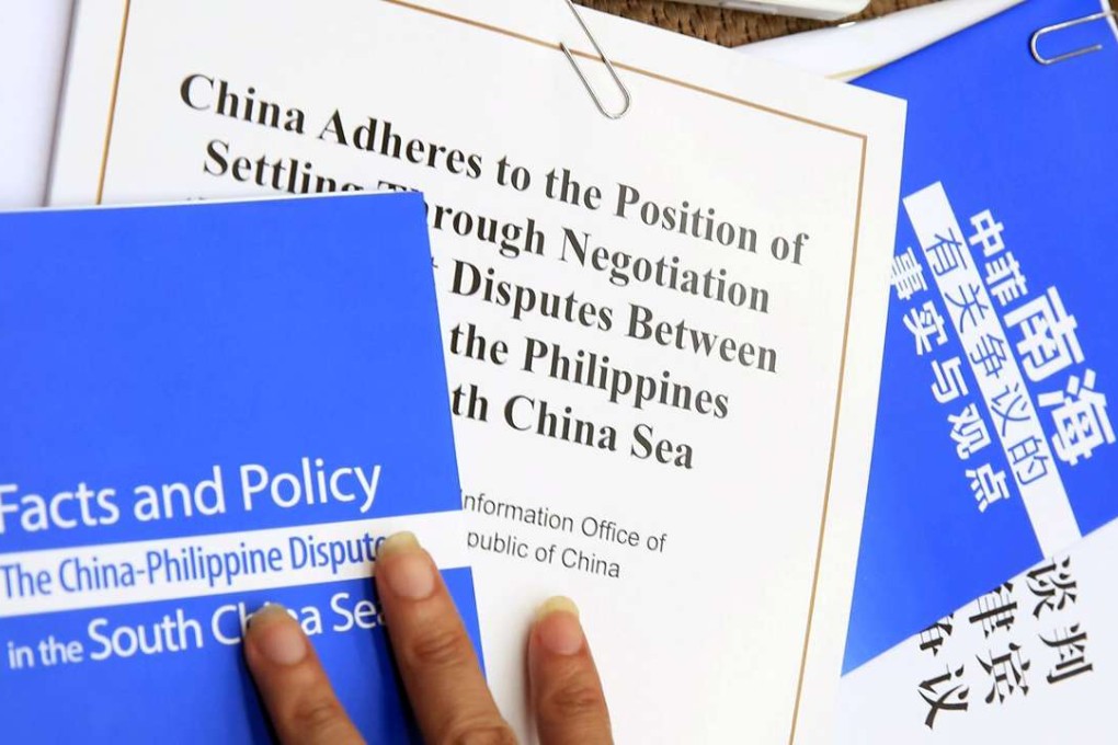 Pamphlets titled 'Facts and Policy; The China-Philippine Dispute in the South China Sea' and the policy paper on China's position on the ruling of an international tribunal on the South China Sea are seen beside a reporter during a press conference in Beijing. Photo: EPA