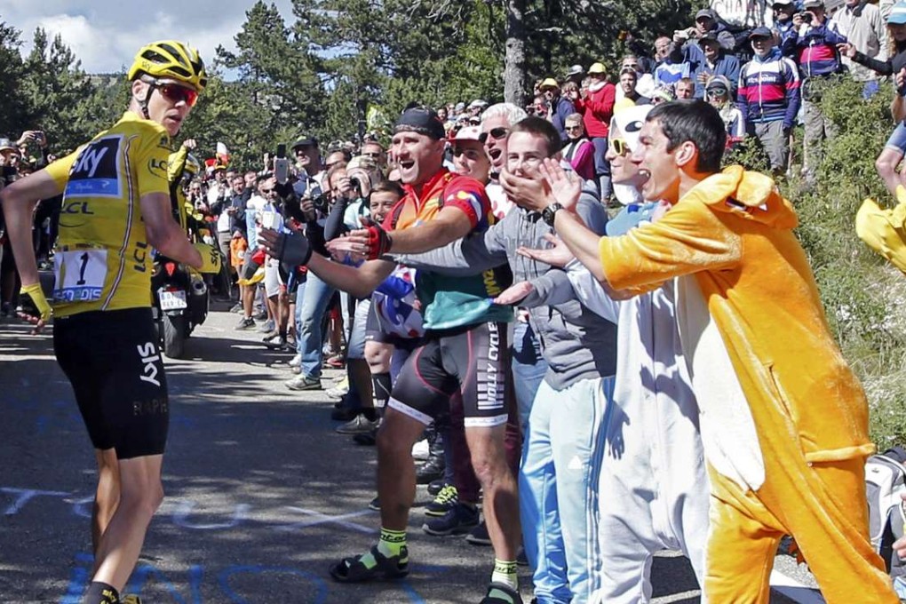 Fans cheer on Team Sky rider Chris Froome as he starts running on the road after a fall that damaged his bike. Photo: Reuters