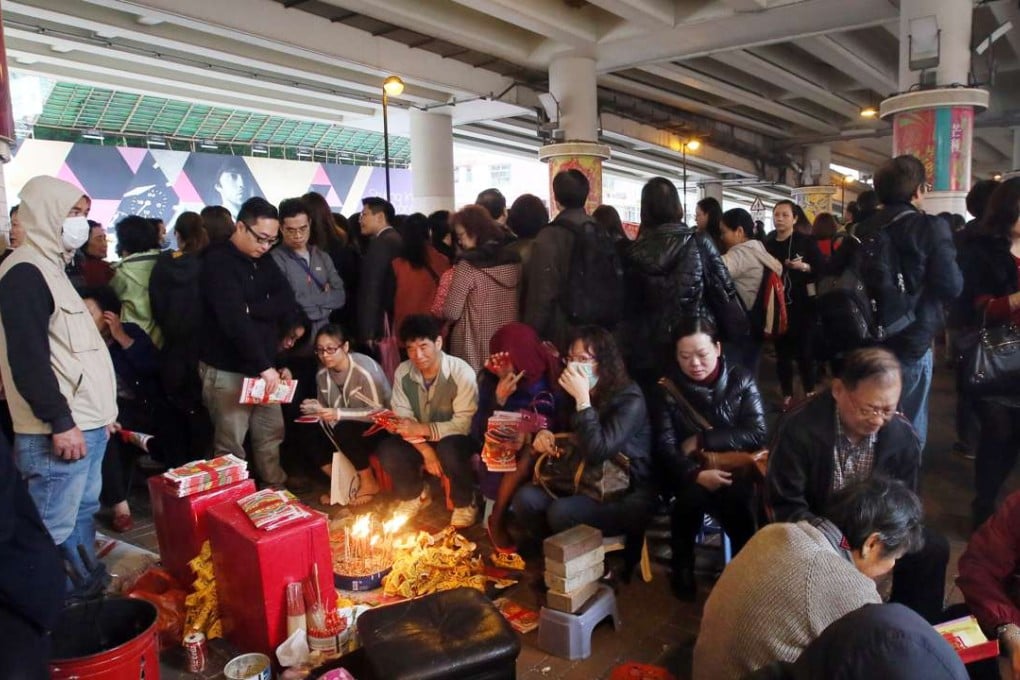 A devil-beater pounds a paper effigy with a shoe under the Canal Road flyover during the Ching Che ferstival in March 2015. Photo: Franke Tsang