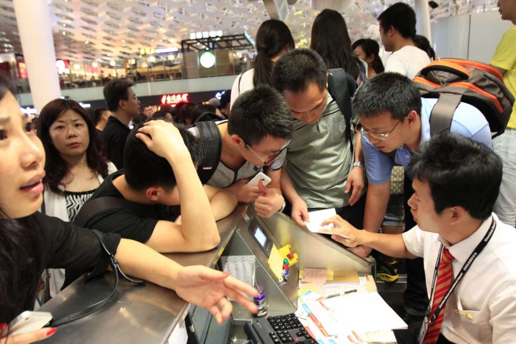 Chinese passengers surround airline staff to check information of their delayed flights at the Shenzhen Baoan airport. Photo: SCMP Pictures