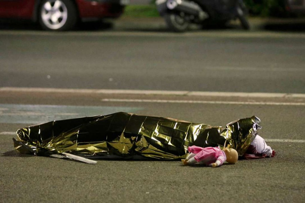A body believed to be that of a child, a doll at their feet, is wrapped in a foil blanket on the Nice promenade in Thursday night. Photo: Reuters