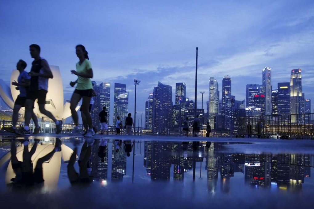 Joggers run past the skyline of Singapore's financial district. Asean members have drawn up a common regulatory framework for liberalising capital markets. Photo: Reuters