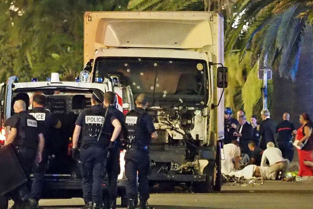 Police stand by as medical personnel attend a person on the ground, right, in the early hours of Friday, July 14, 2016, on the Promenade des Anglais in Nice, southern France, next to the lorry that had been driven into crowds of revellers late on Thursday. Photo: AP