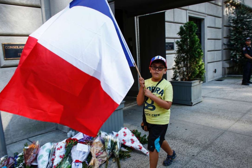 A boy carriers a French flag outside the French Consulate in New York. Photo: AFP