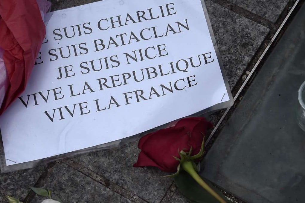 A picture shows a sign reading "I am Charlie, I am Bataclan, I am Nice, long live the Republic, long live France" next to a candle and roses in Strasbourg, eastern France, after a gunman smashed a truck through a crowd celebrating Bastille Day, killing at least 84. Photo: AFP