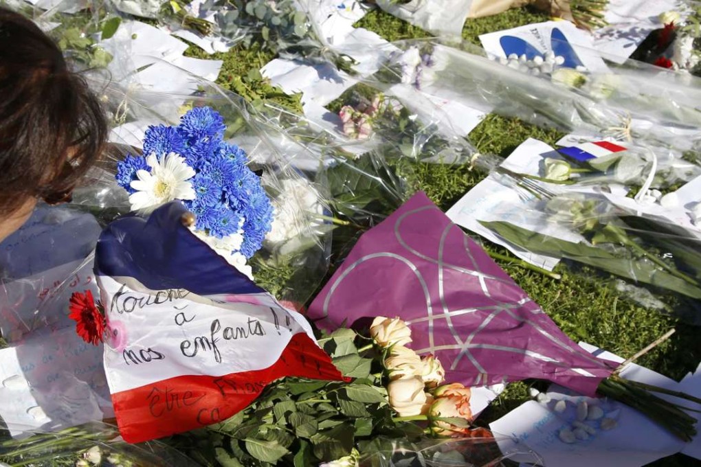 Flowers and a flag placed in tribute to victims two days after the attack in Nice. Photo: Reuters