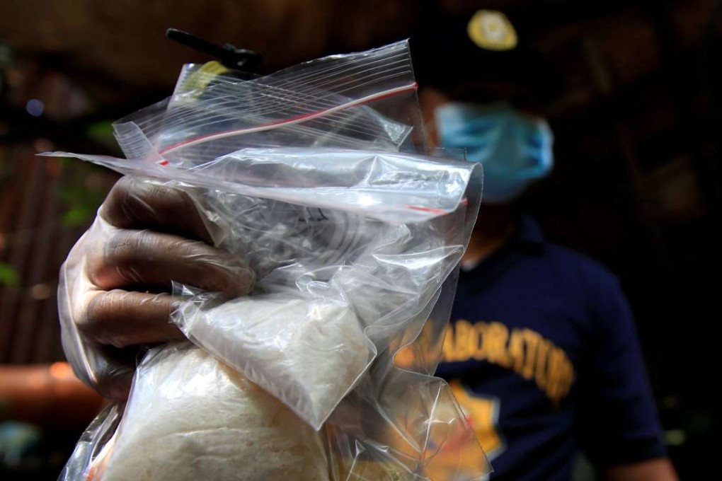 A member of the Philippine National Police (PNP) investigation unit shows confiscated methamphetamine, known locally as Shabu, seized from suspected drug pushers. Photo: Reuters