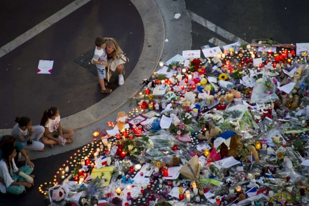 People gather at a makeshift memorial of flowers and candles on the 'Promenade des Anglais', scene of the Bastille Day truck attack tat killed 84 people. Photo: EPA