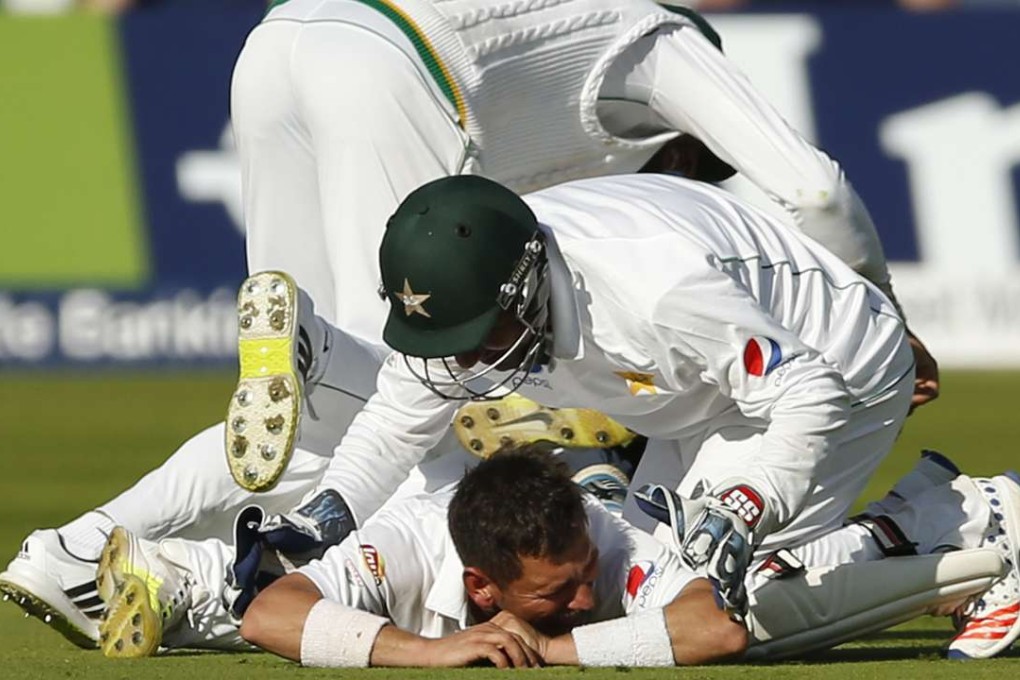 Teammates swamp Pakistan leg-spinner Yasir Shah after he took the wicket of England's Chris Woakes on the fourth day of the first test at Lord’s. Photo: Reuters