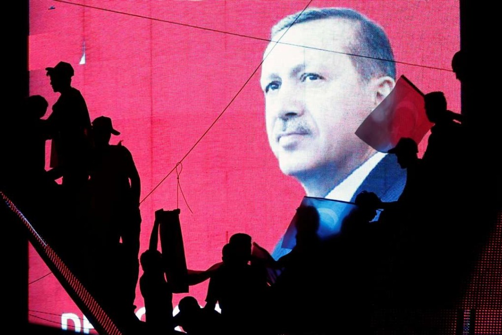 Supporters are silhouetted against a screen showing President Erdogan during a pro-government demonstration in Ankara on Sunday. Photo: Reuters