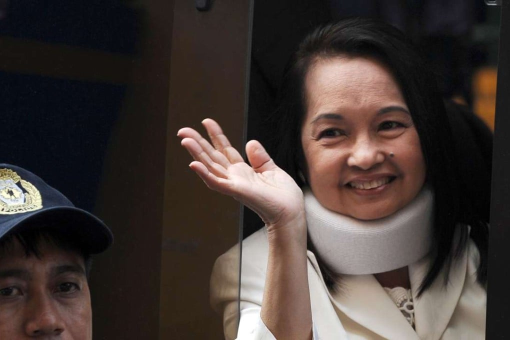 Former Philippine president Gloria Arroyo waves to photographers from a vehicle after appearing in court in 2012. File photo: AFP