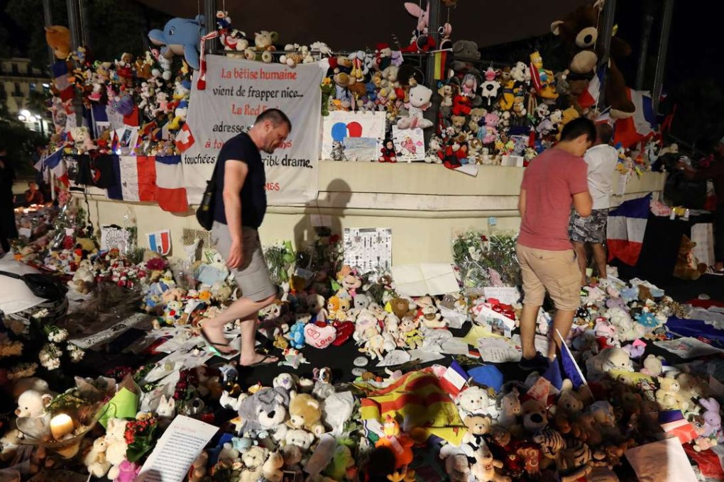 People walk through a makeshift memorial to victims of the Bastille Day truck attack in Nice on Monday. Photo: AFP