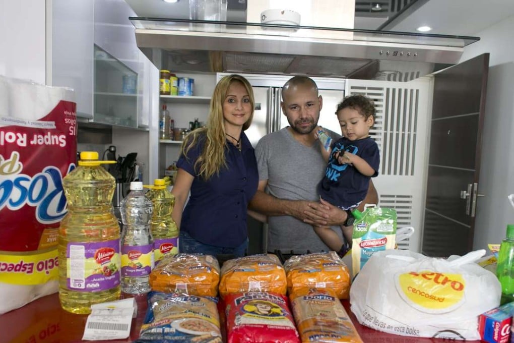 Tebie Gonzalez poses for a portrait on Monday, with husband Ramiro Ramirez and their son, Sebastian, in their home in San Cristobal, Venezuela. Before them is the food they bought the previous day in Colombia. Photo: AP