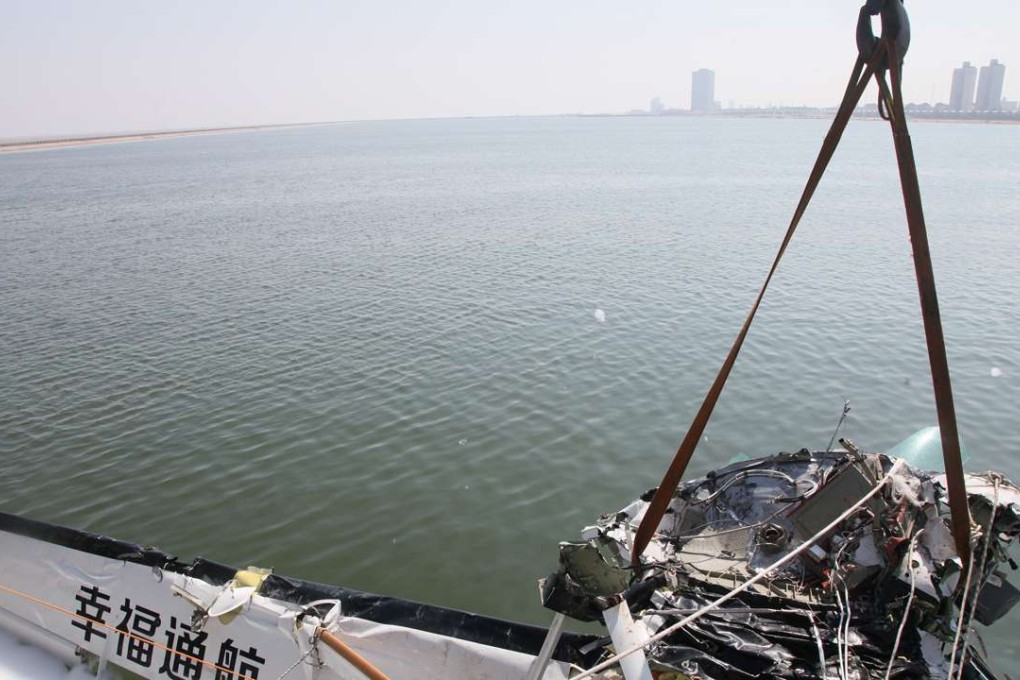 Part of the wreckage of the plane is retrieved from the water. Photo: Xinhua