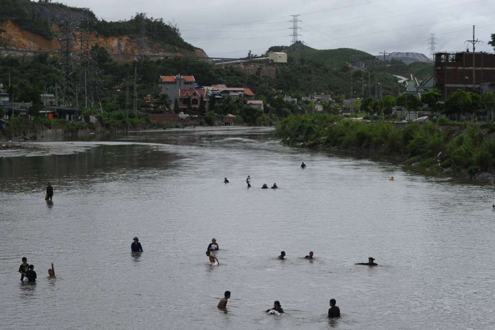 People collect coal from a flooded river next to the Mong Duong mine following heavy rains in the northern Vietnamese province of Quang Ninh, in August 2015. Picture: AFP
