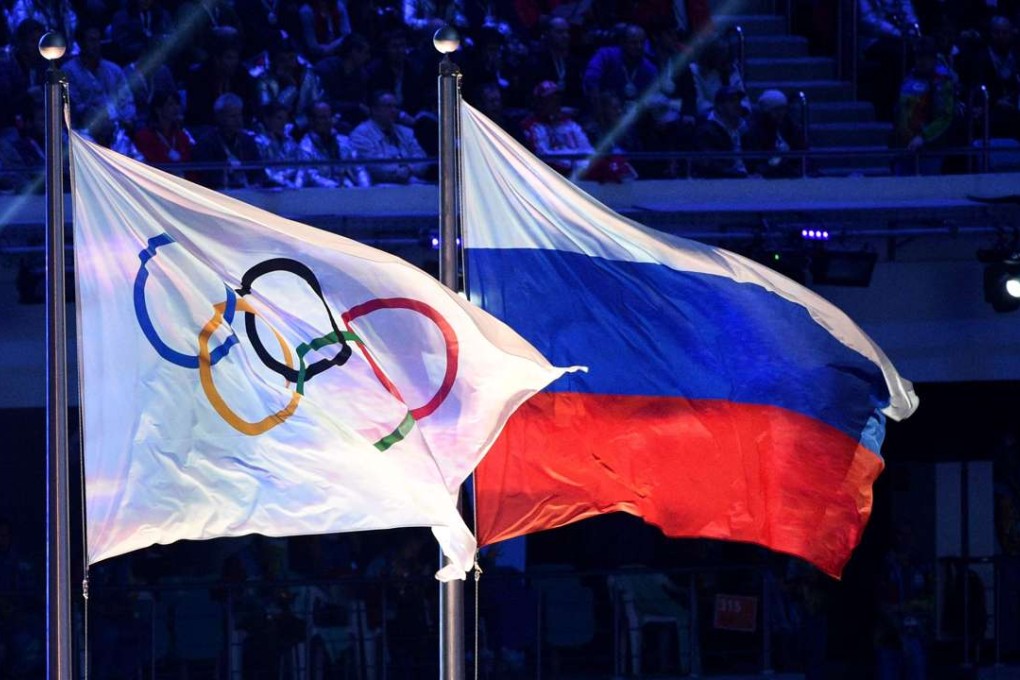 The Olympic Games flag and a Russian flag during the closing ceremony of the winter Olympics in Sochi. Photo: AFP