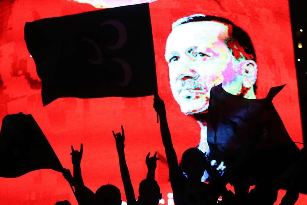 Supporters stand in front of a screen displaying a portrait of Turkish President Recep Tayyip Erdogan during a rally at Kizilay Square in Ankara. Photo: AFP