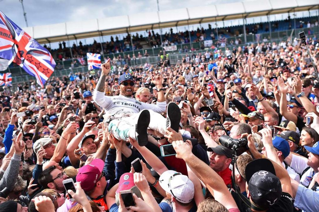 Lewis Hamilton crowd-surfs with the fans after winning the British Formula One Grand Prix. AFP
