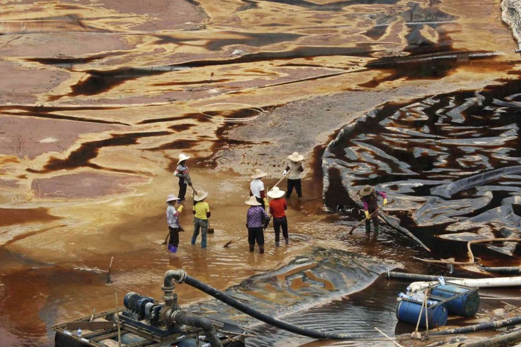 Labourers work to drain sewage water from a leaked sewage tank at a copper mine in Shanghang, Fujian province. China’s mining industry is notorious for its environmental damage, and the pollution is usually irreversible. Photo: Reuters