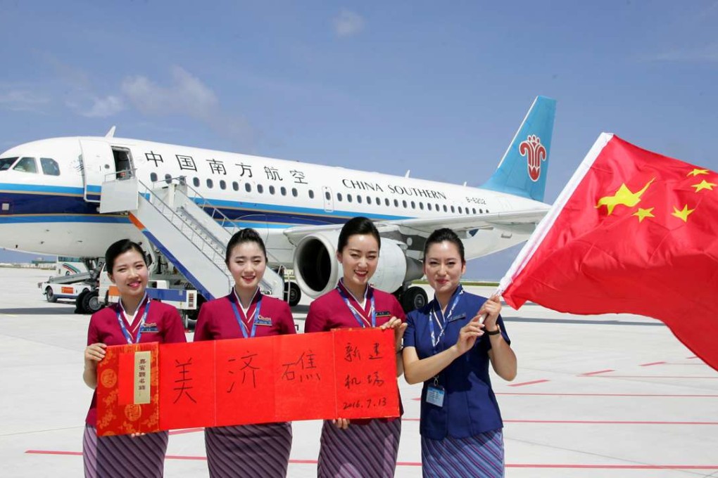 Crew members pose in front of a plane that China Southern Airlines landed at a new airport China has built on Mischief Reef in the South China Sea. Photo: Reuters