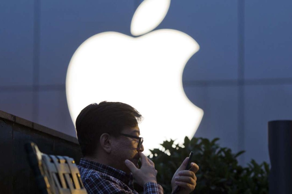 A man uses his mobile phone near a Apple store. Photo: AP Photo